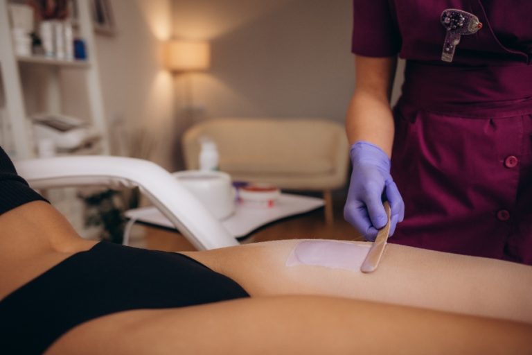 Esthéticienne réalisant une séance d’épilation définitive sur les jambes, avec tarif indiqué à titre indicatif