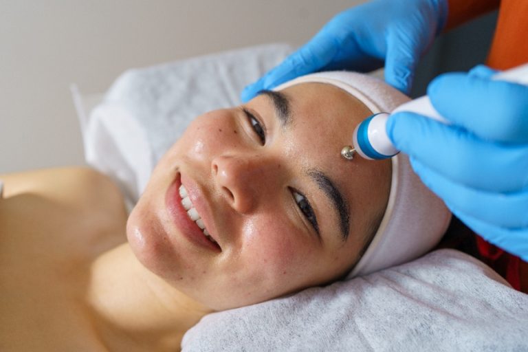 Une esthéticienne applique le soin de micro dermabrasion sur un visage détendu