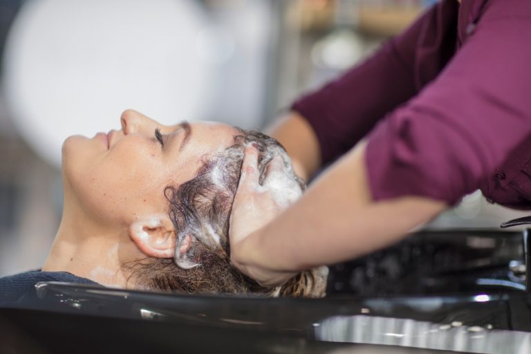 Une coiffeuse applique un soin botox nourrissant sur des longueurs humides