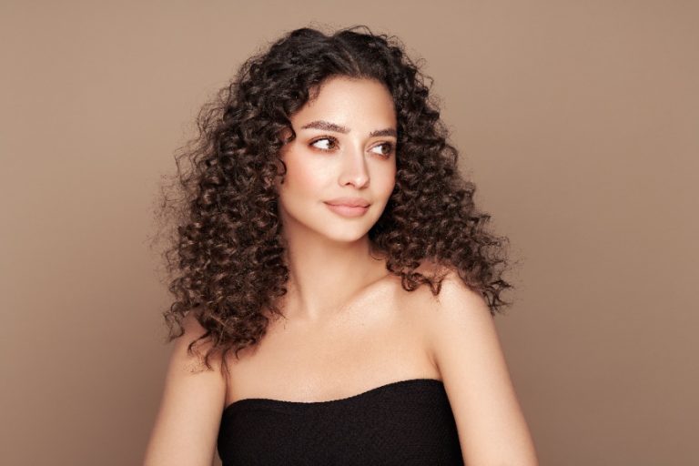 Femme observant ses cheveux devenus bouclés du jour au lendemain devant un miroir