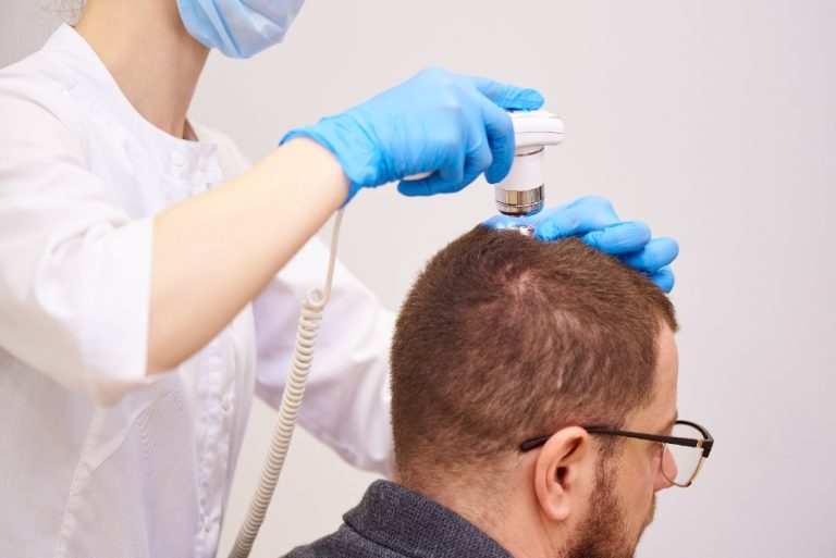 Un patient assis dans un cabinet parisien discute du devis pour sa greffe capillaire