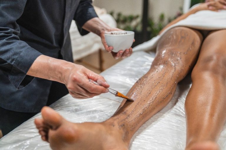Application de cire chaude sur la jambe avant l’arrachage des poils