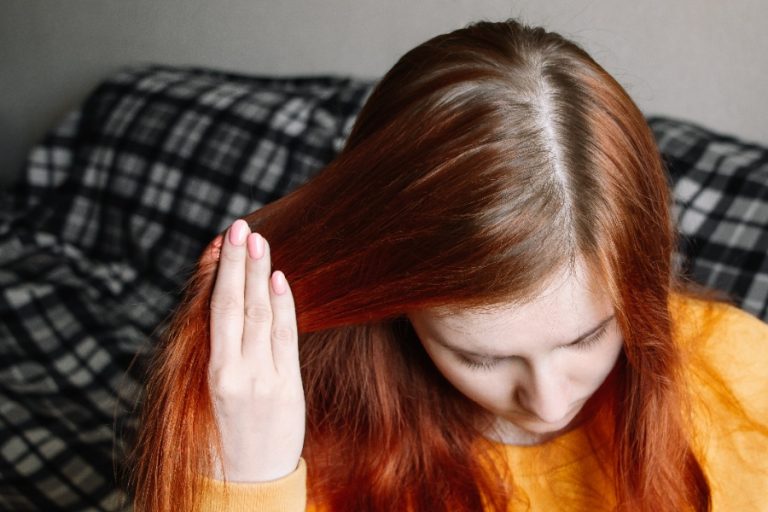 Coiffeuse préparant la transition d’une coloration rouge vers un marron naturel