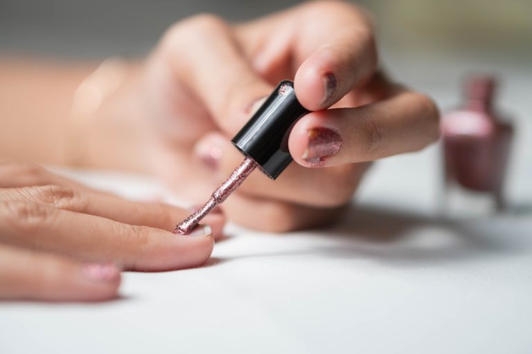 Une personne qui applique un vernis semi-permanent