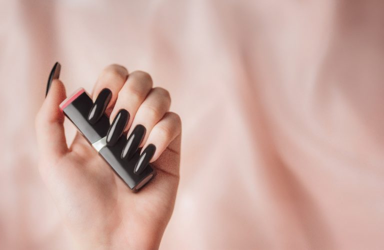 Une personne montrant le résultat de sa pose de vernis semi-permanent sur capsule sans utiliser du gel