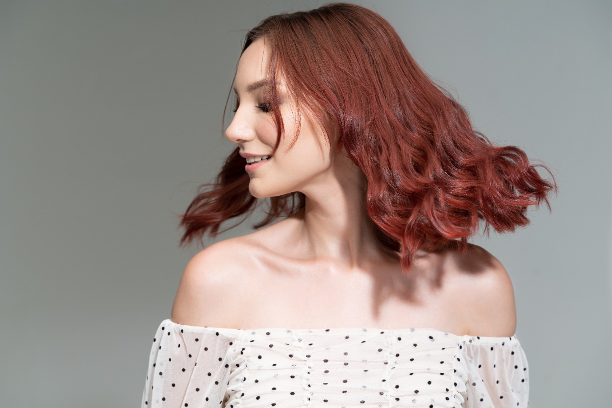 Une belle femme ayant de mini-vague sur des cheveux colorés