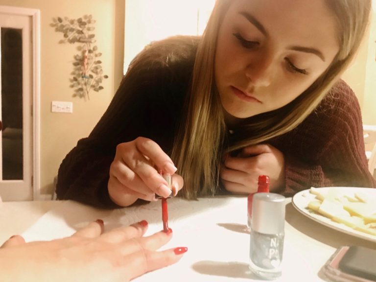 Une adolescente qui aide son amie à mettre de l'ongle en gel