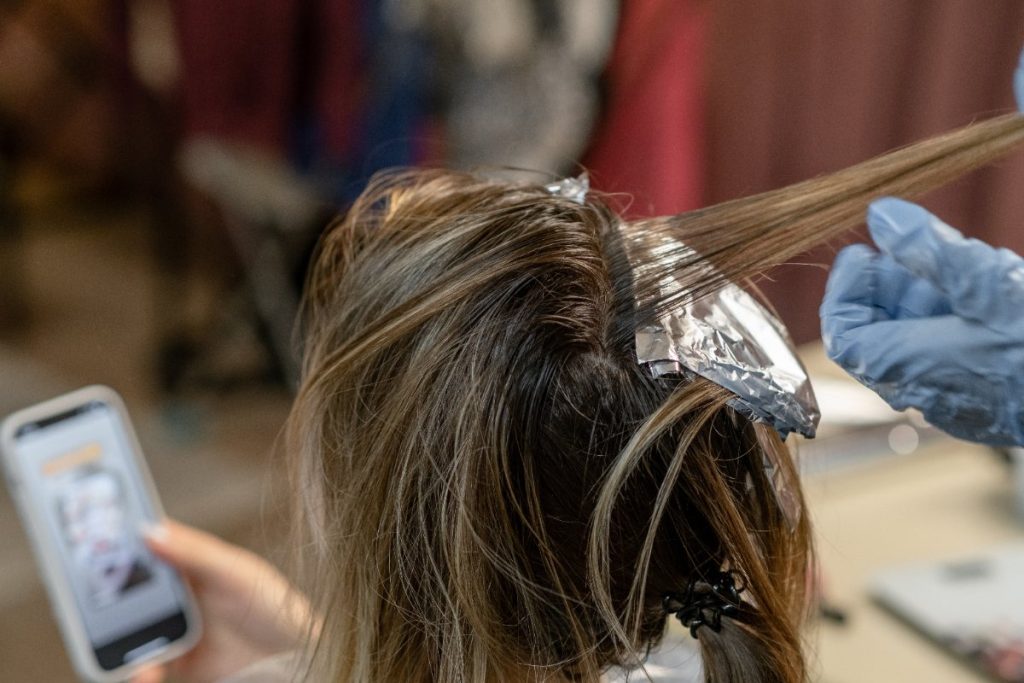 Une femme qui se fait colorer et balayer les cheveux