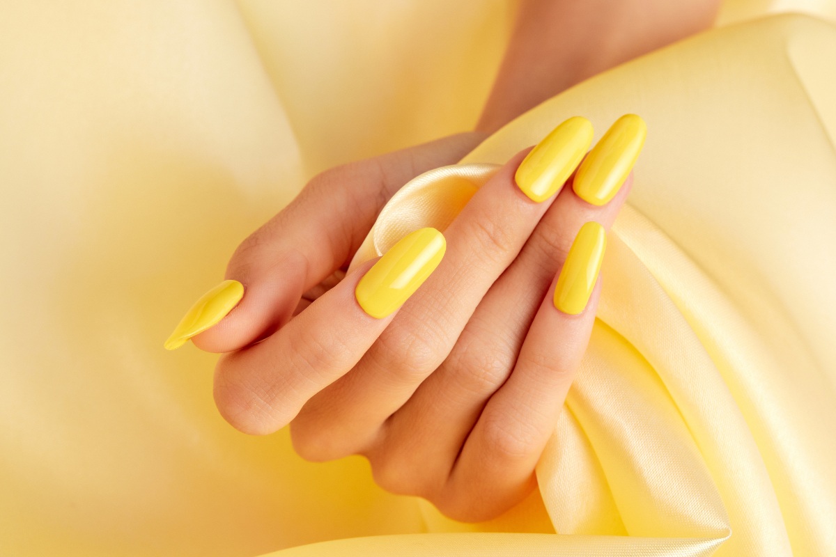Une jolie main avec des ongles jaunes