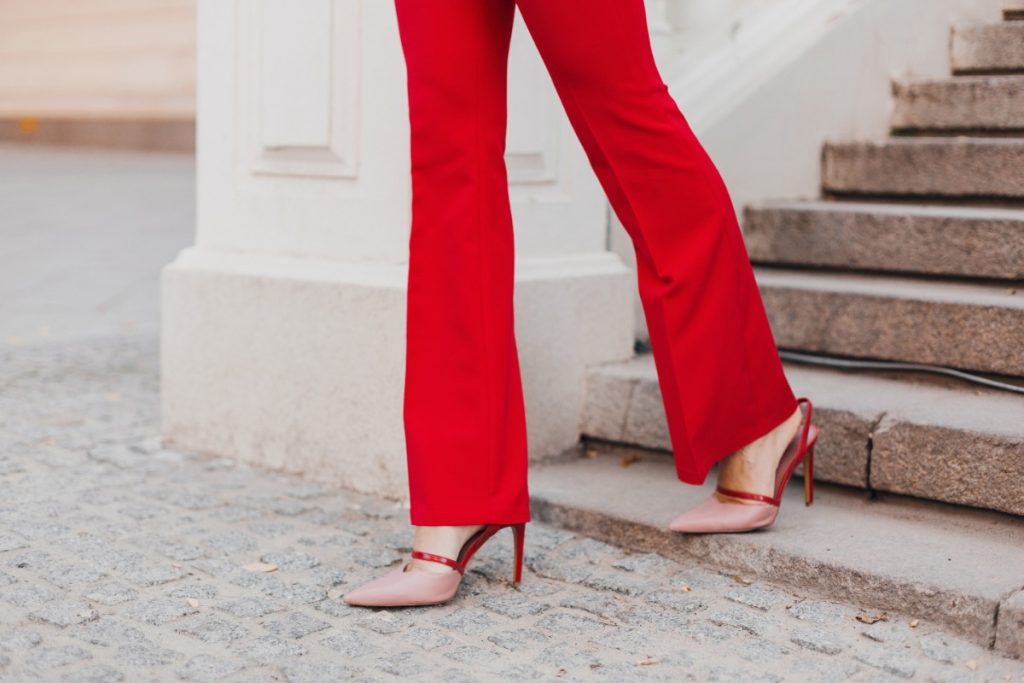 Une femme portant un pantalon évasé rouge et un talon pointu
