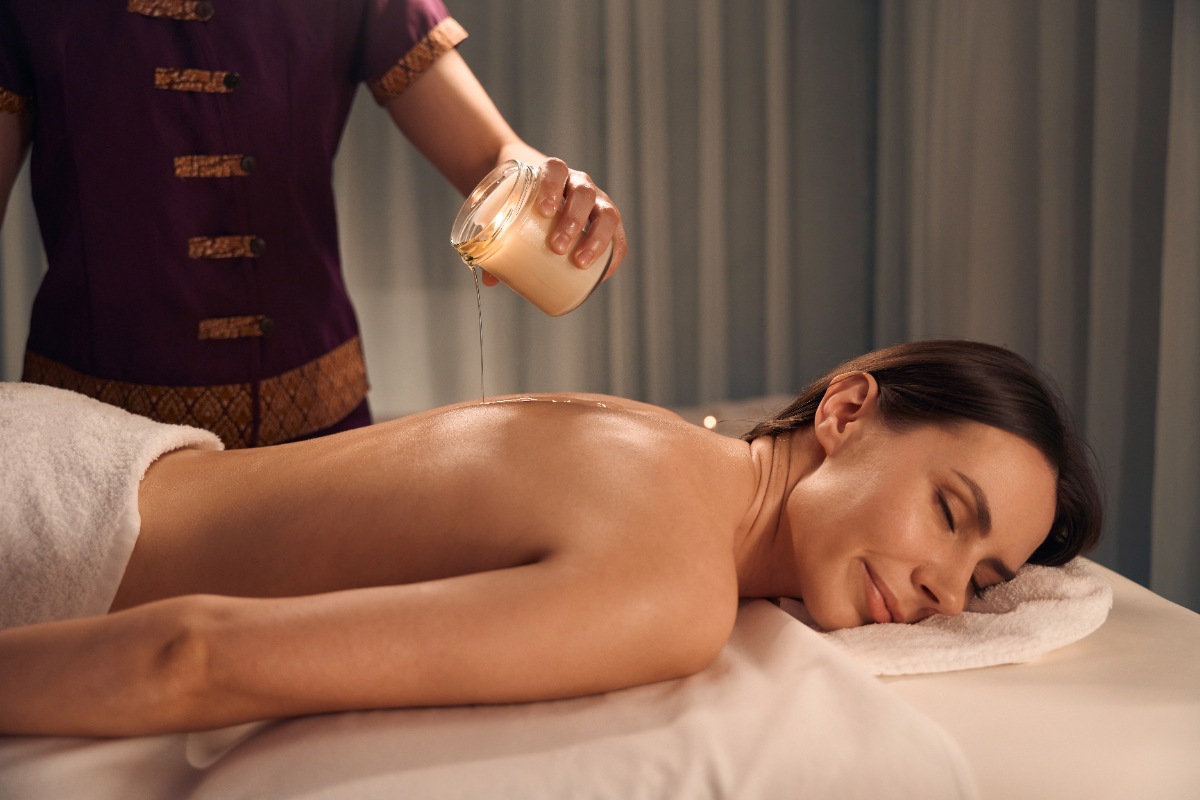 Une femme recevant un massage rajeunissant avec une bougie de massage
