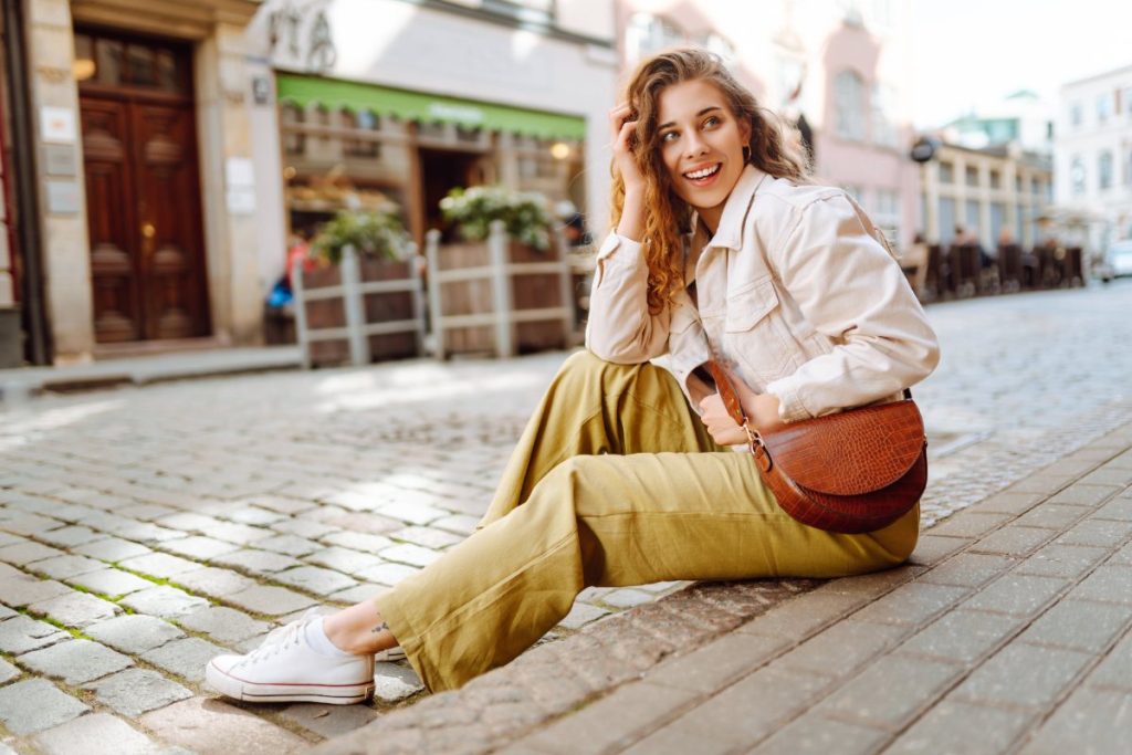 Une femme souriante assise sur un escalier