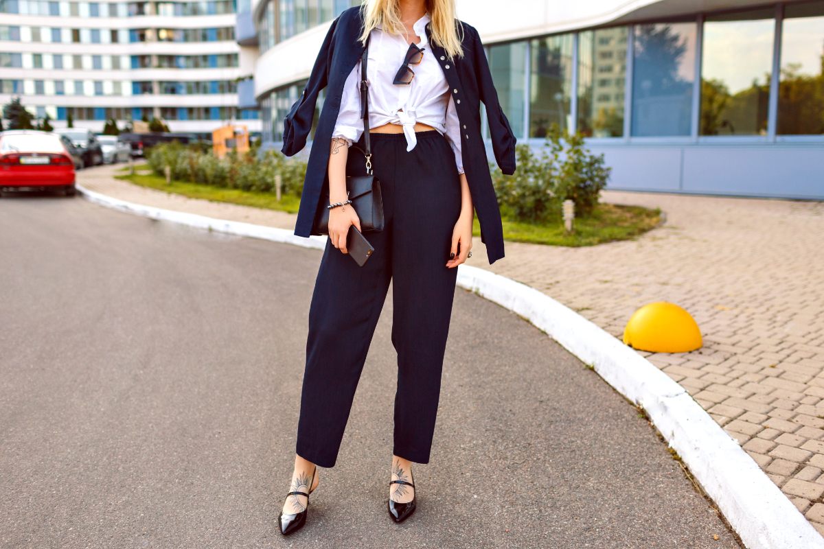 Une femme stylée qui porte un pantalon long et une chemise blanche