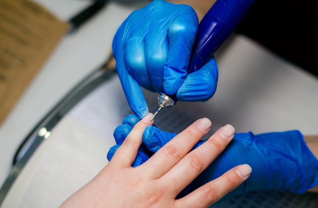 Une esthéticienne qui soigne les ongles d'une personne