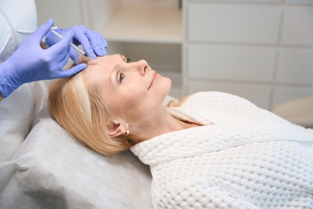 Une femme recevant un soin botox sur le front