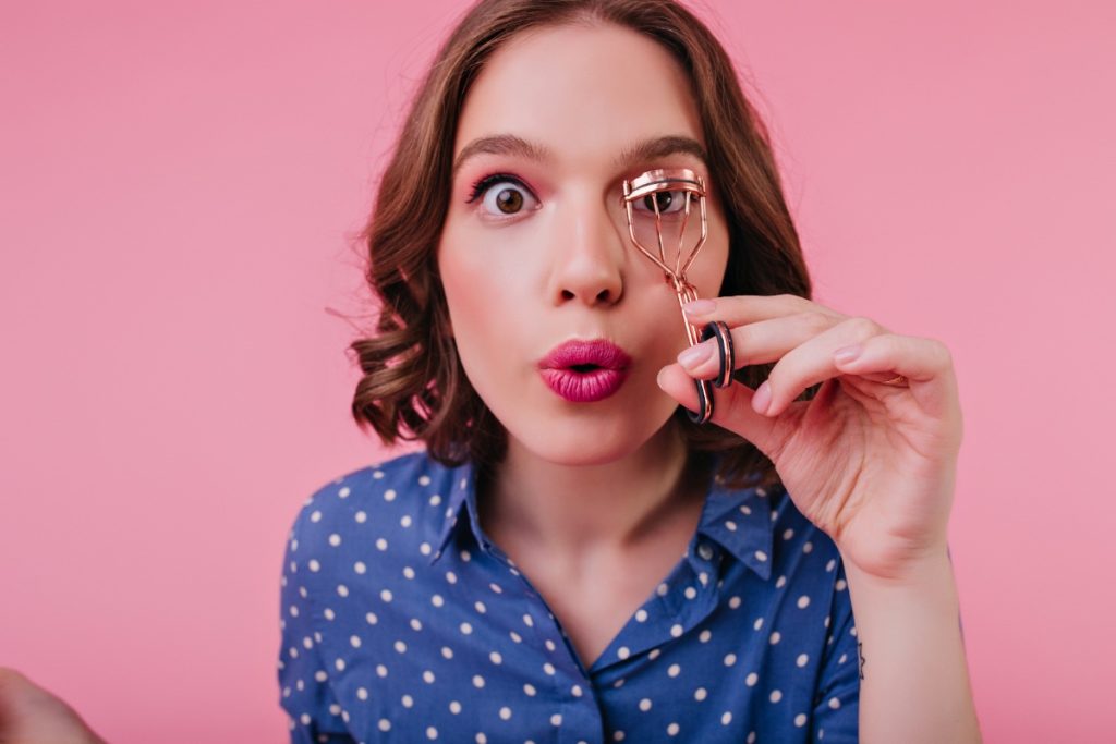 Une femme aux yeux bruns mettant des faux cils