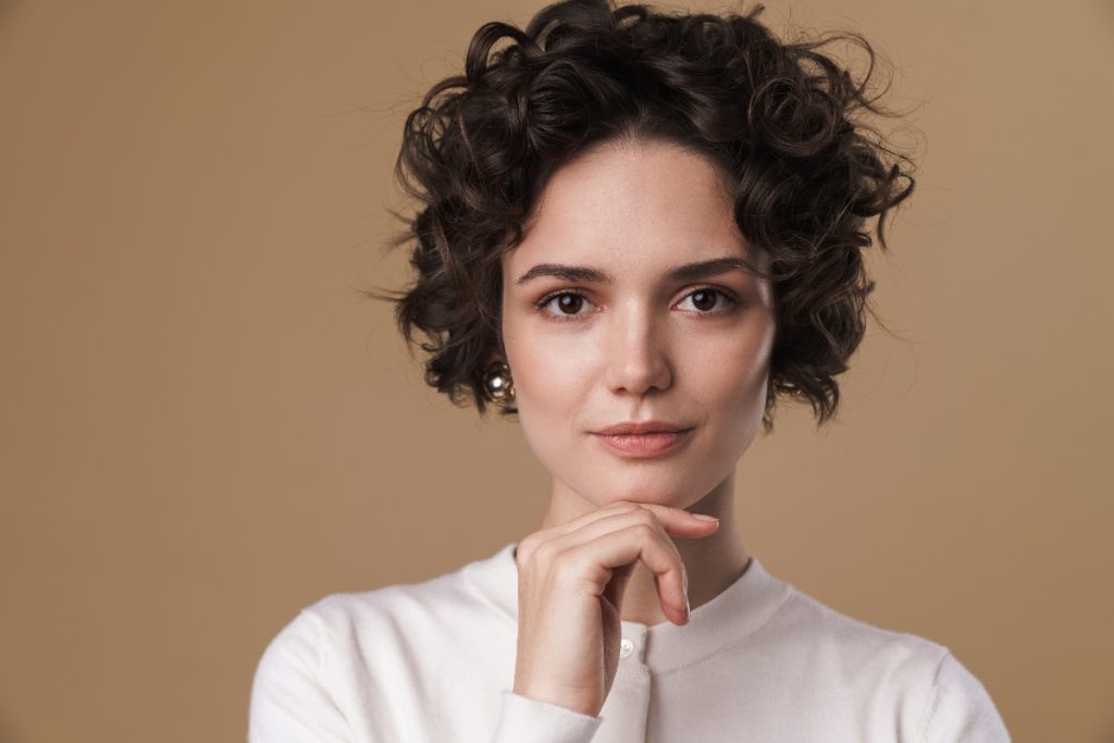 Une femme élégante avec des cheveux bruns bouclés