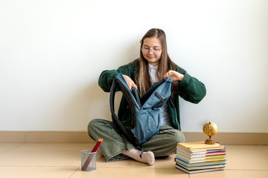 Une jeune étudiante rangeant ses affaires dans son sac