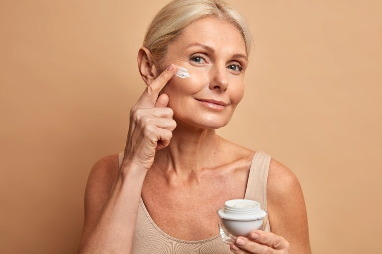 Une femme qui applique de la crème sur le visage