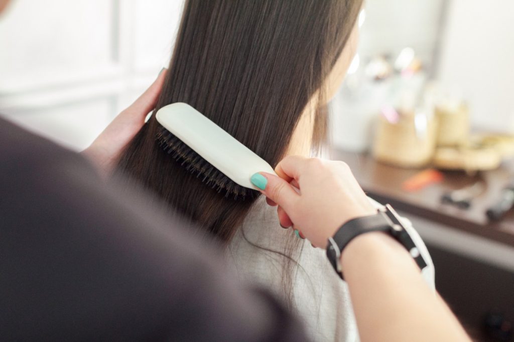 Une femme qui se fait brosser ses longs cheveux