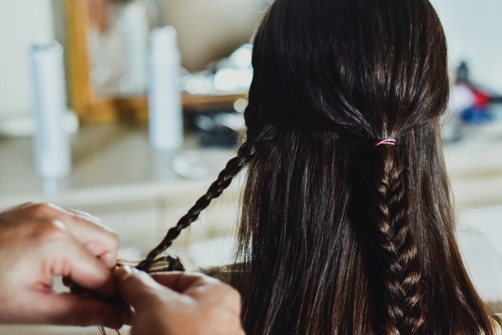 Une femme qui se fait tresser dans un salon de coiffure