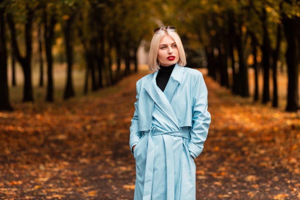 Une femme avec un manteau bleu et se promenant dans la forêt