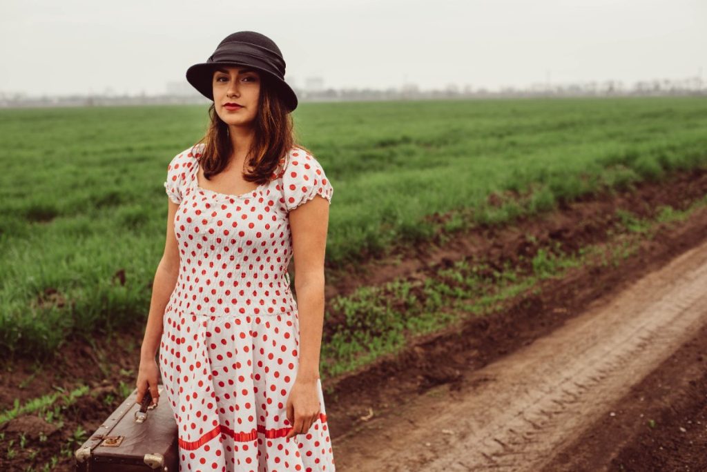 Une femme marchant sur un champ avec une valise