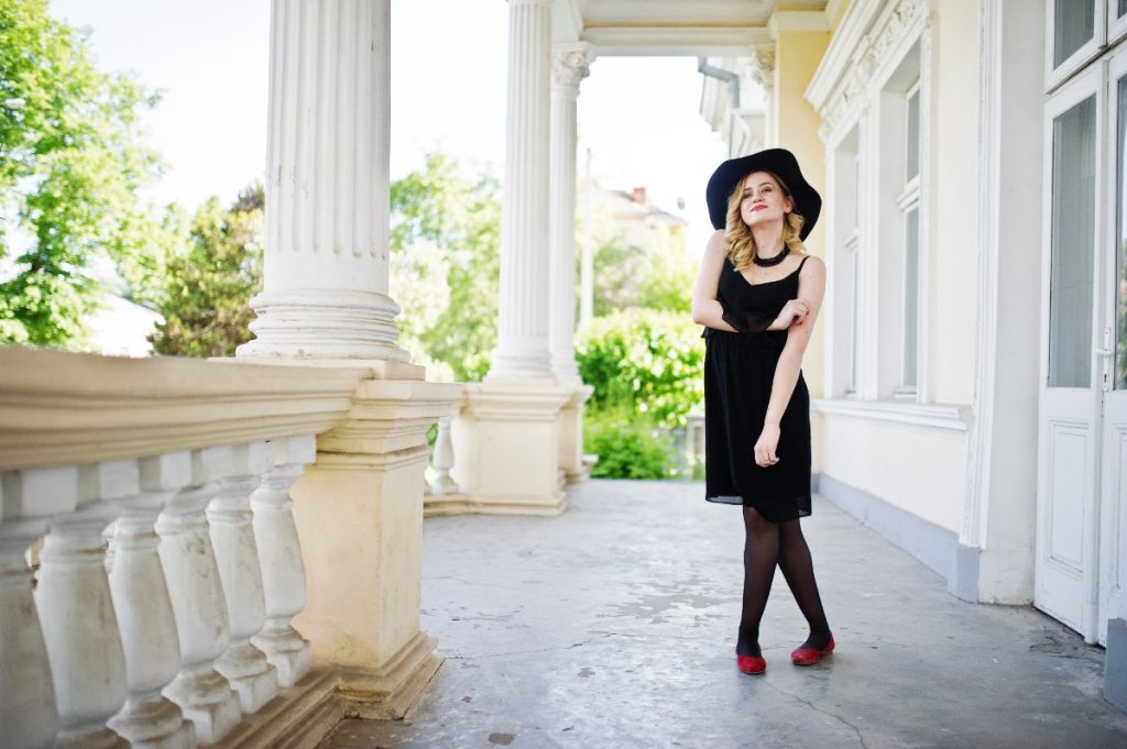 Une femme en robe et chapeau noir