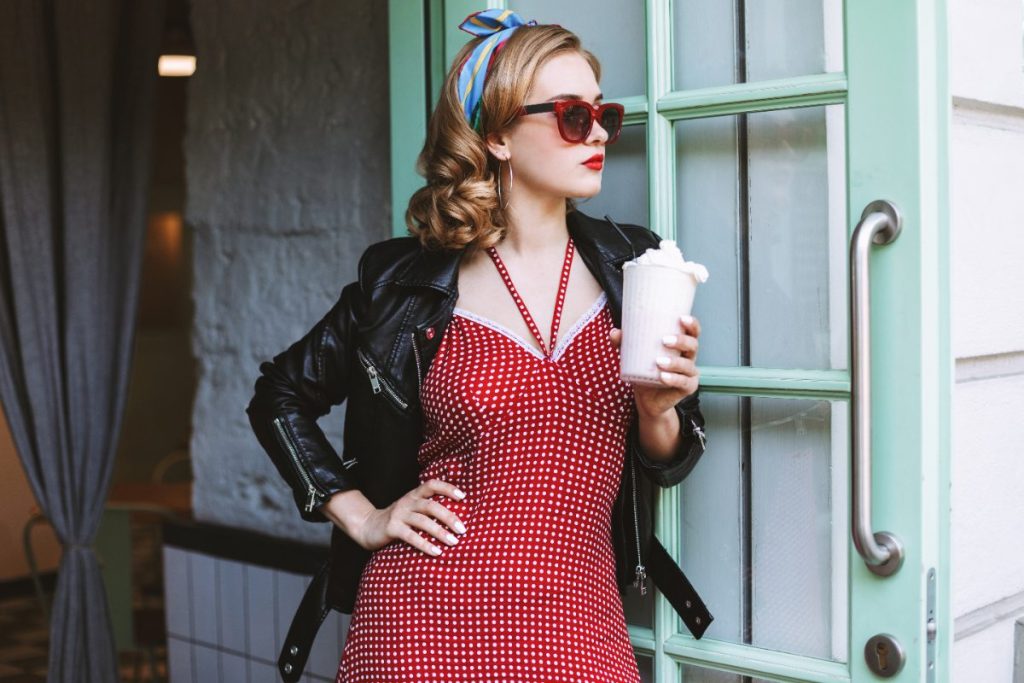 Une femme avec une robe à pois tenant un milkshake