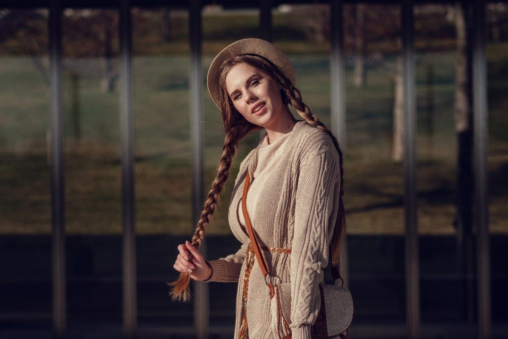 Une femme stylée avec des cheveux tressés et un chapeau