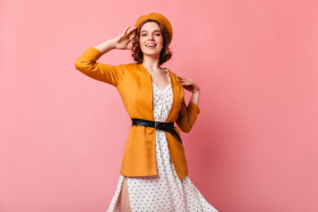 Une femme en veste moutarde avec une robe à pois