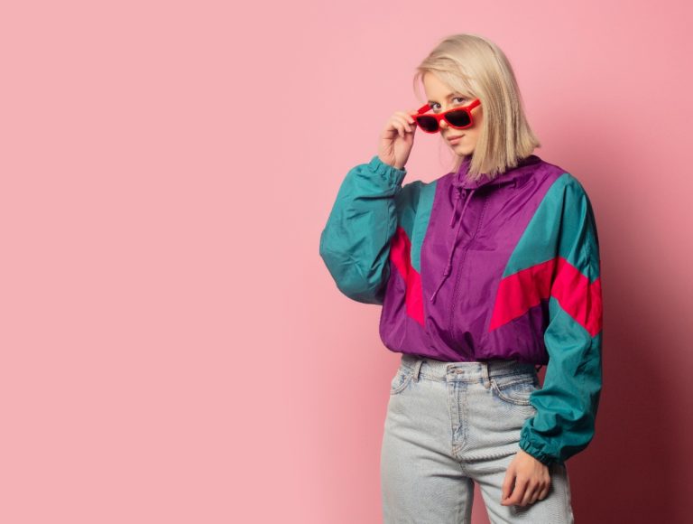Une jeune femme portant une lunette de soleil avec une veste colorée