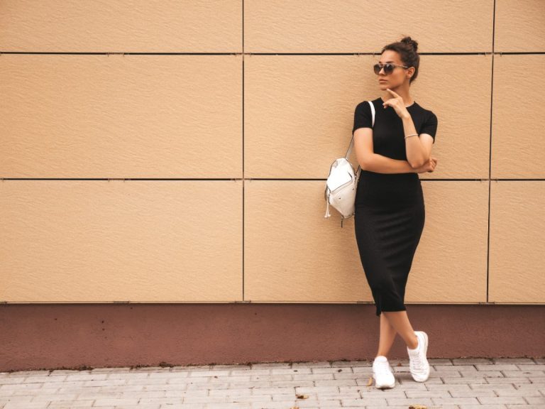 Une jeune femme stylée en robe noire avec un petit sac blanc