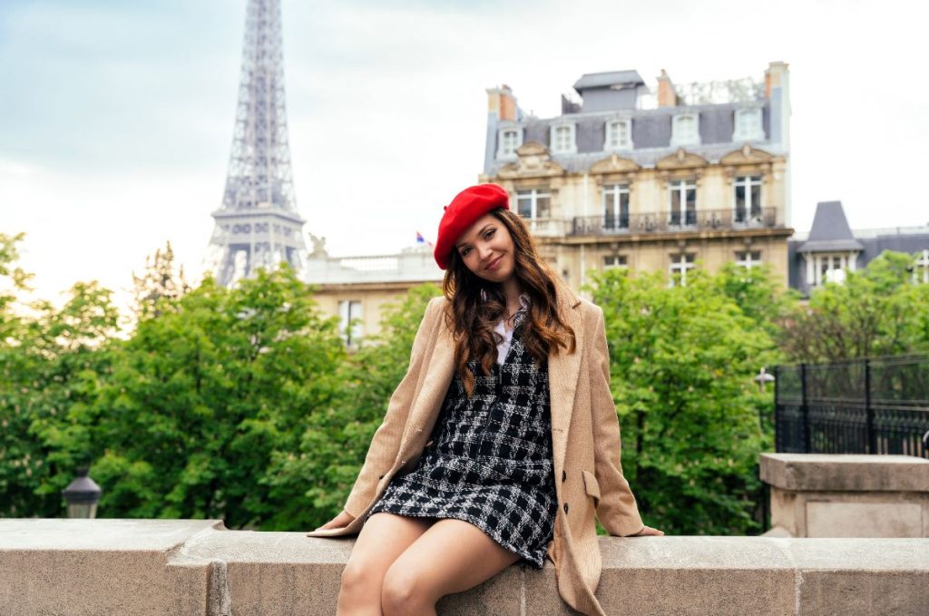 Une jolie fille assise au bord d'une jardinière à Paris
