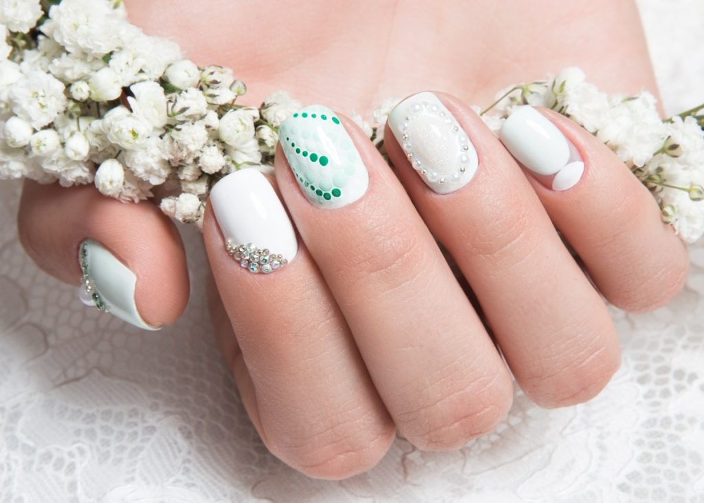 Main avec des ongles manucurés tenant des fleurs